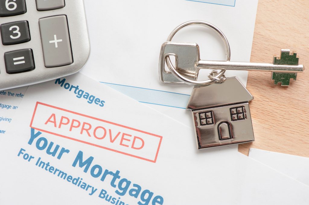What affects mortgage approval? Approved stamp on paper with a house key.