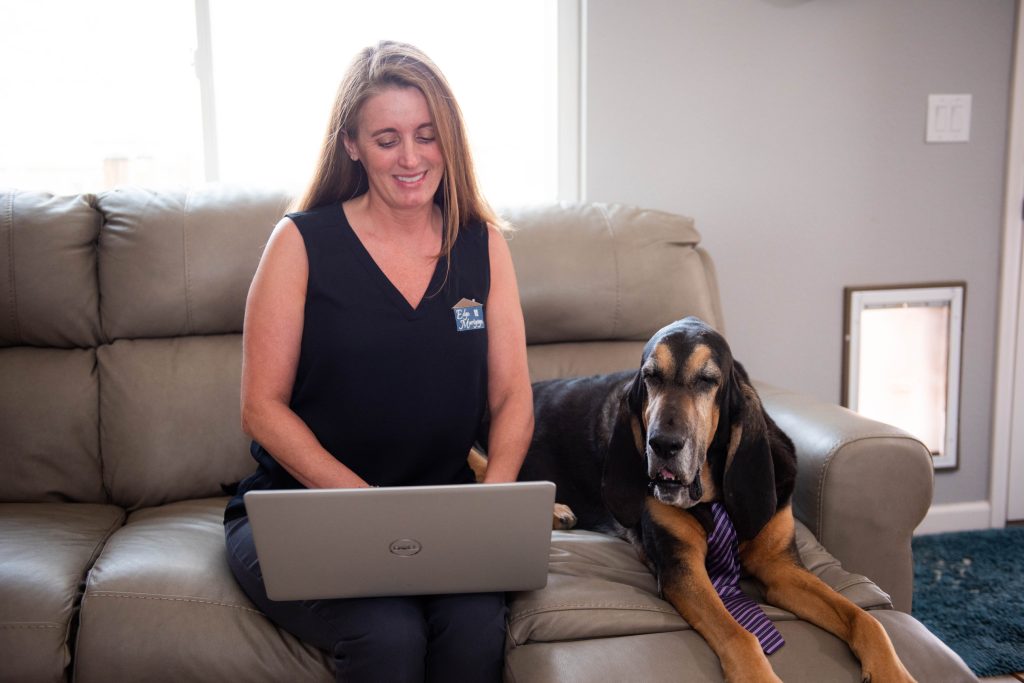 How to get a mortgage with bad credit. Edge Mortgage Inc. Sitting on the couch on the computer next to dog.