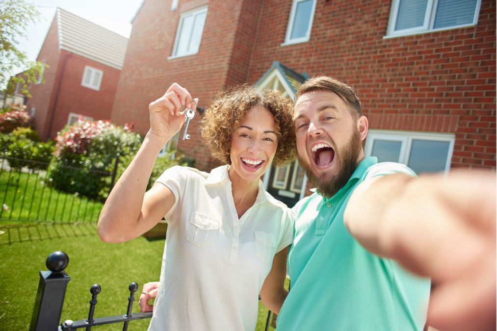 first-time home buyer programs - Couple excited with keys to house