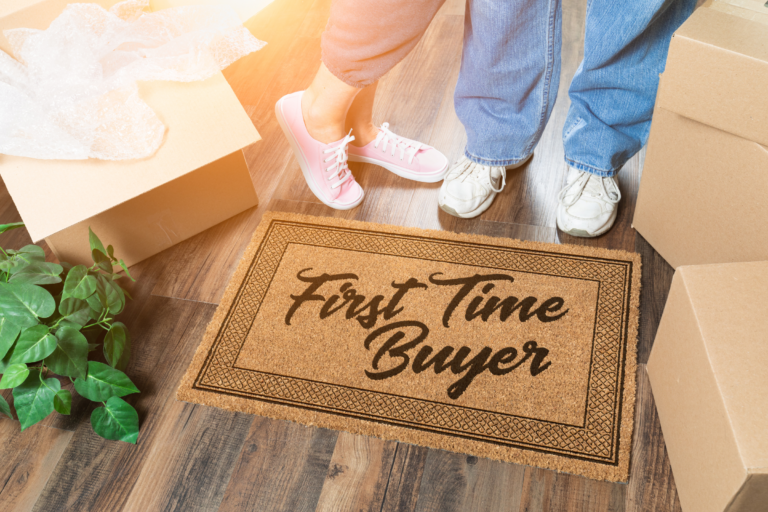 What to know before buying a house the first time. Couple standing on a first time buyer welcome mat.